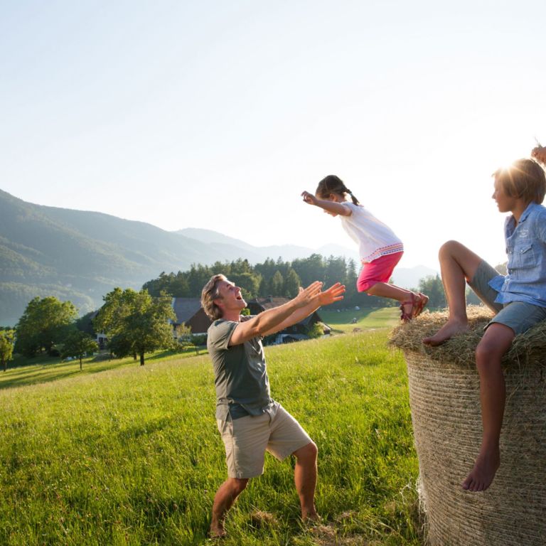 Kinder mit Vater auf Heuballen © Salzburger Land Tourismus
