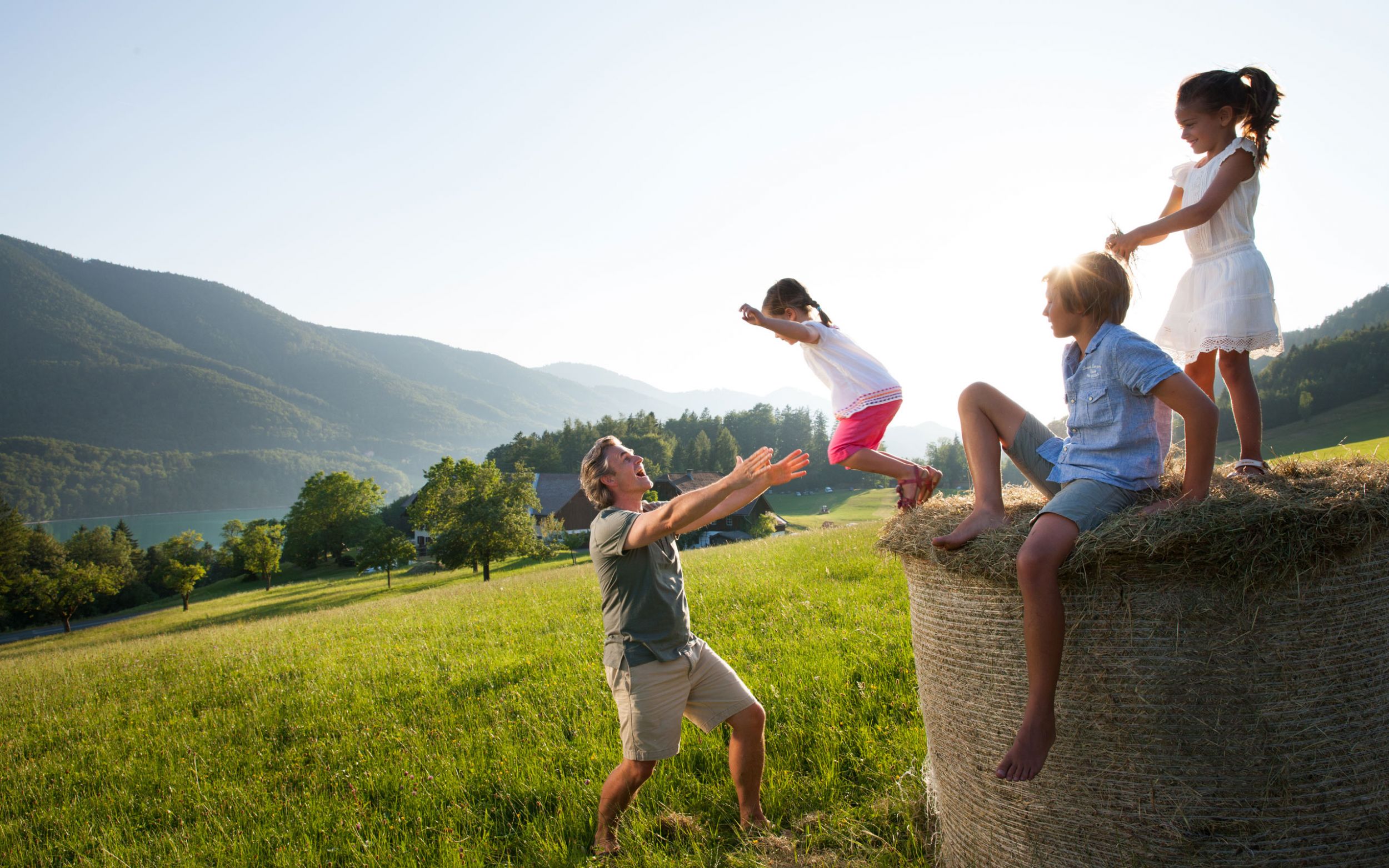 Kinder mit Vater auf Heuballen © Salzburger Land Tourismus